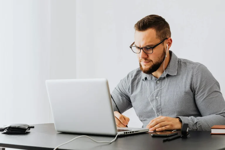 Hombre estudiando con laptop y auriculares, representando el bachillerato acelerado online en Ecuador con educación flexible y acompañamiento